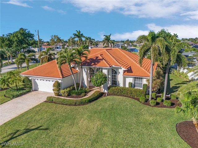 mediterranean / spanish-style house with a garage and a front lawn