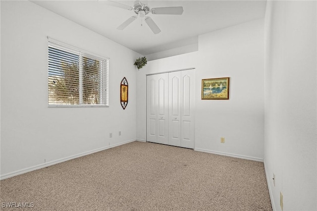 unfurnished bedroom with ceiling fan, a closet, and light colored carpet