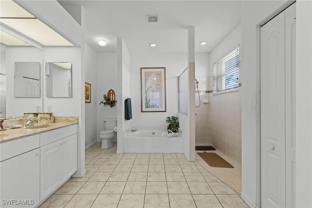 full bathroom featuring tile patterned floors, vanity, shower with separate bathtub, and toilet