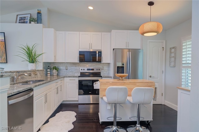 kitchen featuring sink, light stone countertops, decorative light fixtures, white cabinetry, and stainless steel appliances