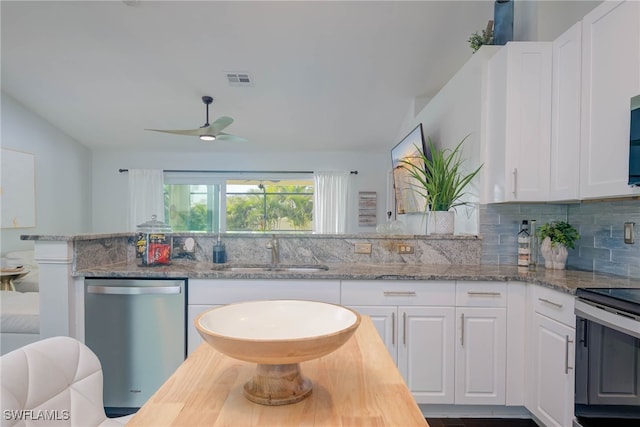 kitchen featuring white cabinetry, light stone countertops, vaulted ceiling, and appliances with stainless steel finishes