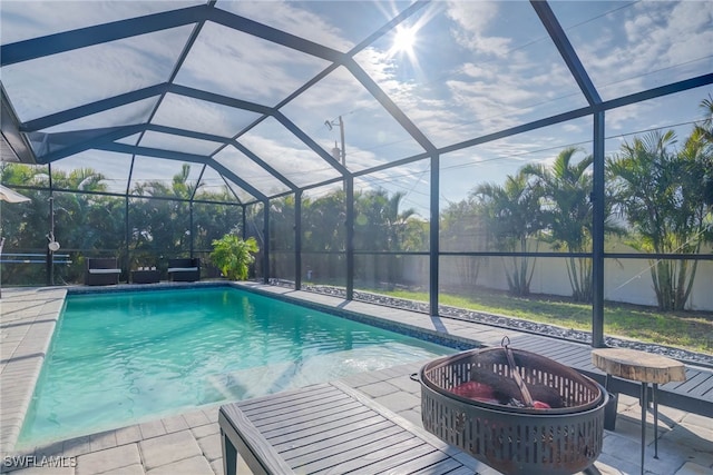 view of pool with a lanai, a patio, and an outdoor fire pit