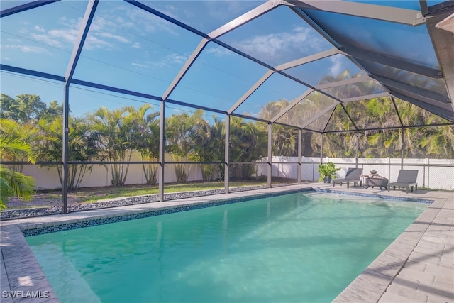 view of pool with glass enclosure and a patio