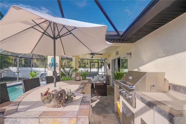 view of patio / terrace with an outdoor kitchen, ceiling fan, glass enclosure, a fenced in pool, and a grill