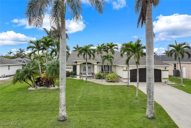 view of front of home featuring a garage, a front lawn, french doors, and central AC unit