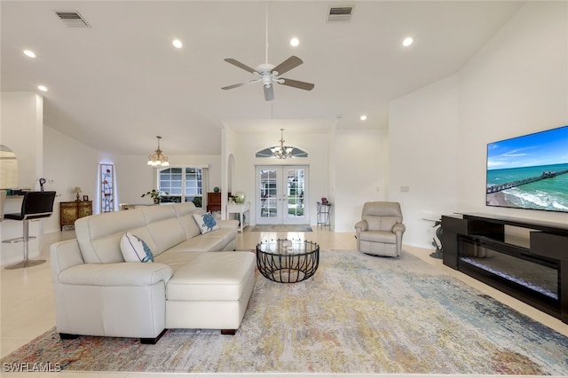 living room featuring french doors and ceiling fan with notable chandelier