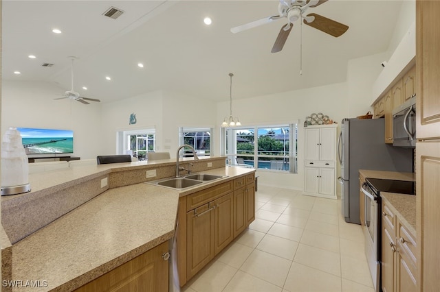 kitchen featuring decorative light fixtures, stainless steel appliances, sink, vaulted ceiling, and light tile patterned floors