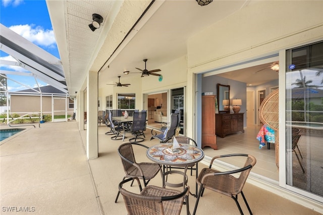 view of patio with ceiling fan and a lanai