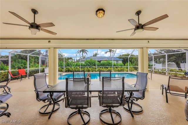 view of pool with glass enclosure, ceiling fan, and a patio