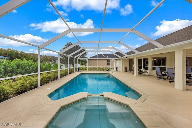 view of swimming pool featuring a patio area, glass enclosure, and an in ground hot tub