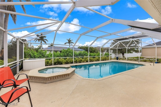 view of swimming pool with glass enclosure, an in ground hot tub, and a patio