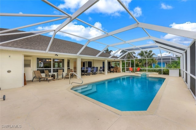 view of swimming pool featuring a patio, glass enclosure, and an in ground hot tub