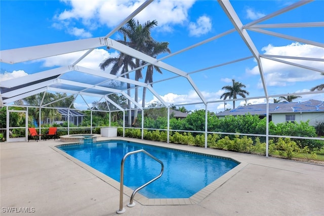 view of pool with glass enclosure, an in ground hot tub, and a patio