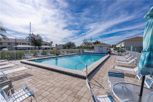 pool featuring a patio, fence, and a residential view