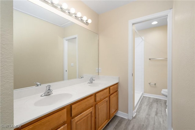 bathroom featuring walk in shower, toilet, vanity, and hardwood / wood-style flooring