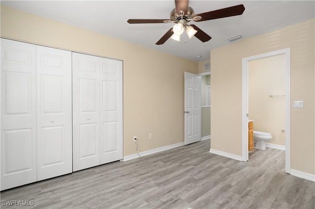 unfurnished bedroom with ceiling fan, a closet, ensuite bathroom, and light hardwood / wood-style flooring