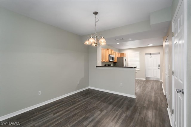 spare room with dark hardwood / wood-style flooring and a notable chandelier