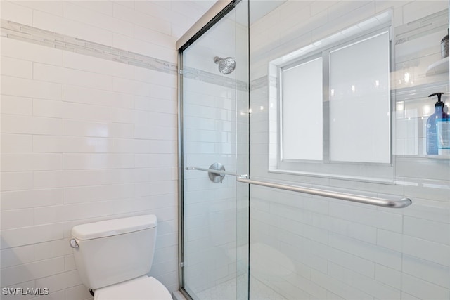 bathroom with toilet and an enclosed shower