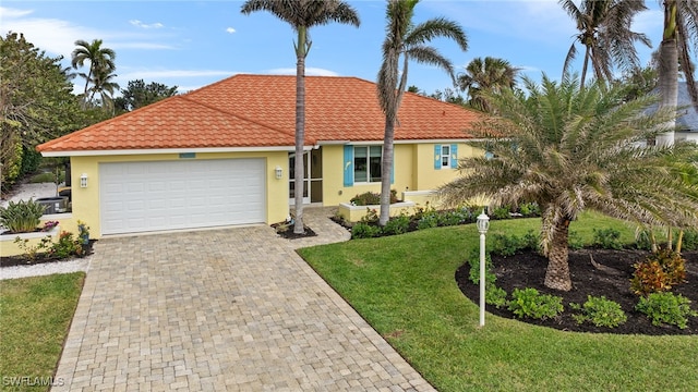 ranch-style house with a garage and a front lawn