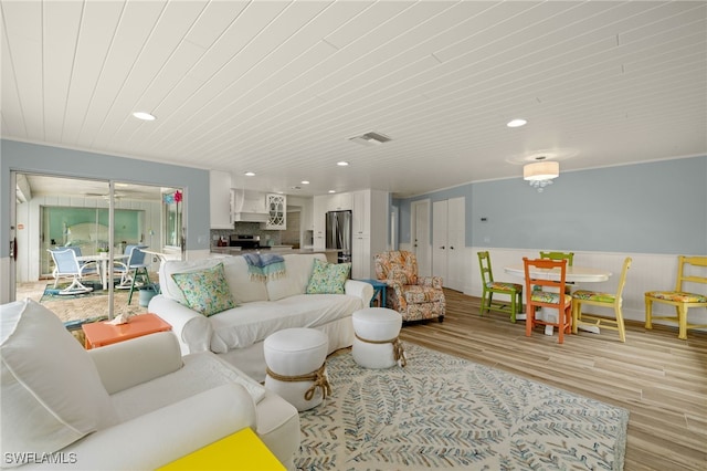 living room with wood ceiling, crown molding, and light hardwood / wood-style flooring