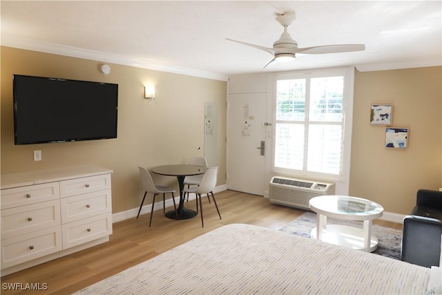 bedroom with ceiling fan, light hardwood / wood-style floors, ornamental molding, and a wall mounted AC