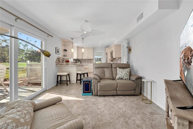 tiled living room featuring ceiling fan