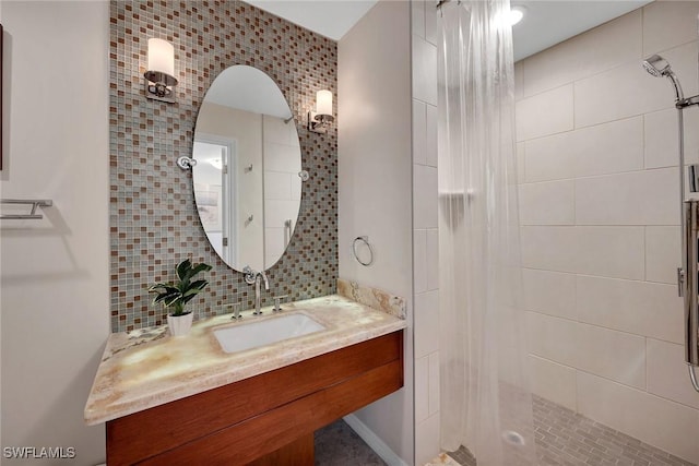 bathroom with decorative backsplash, vanity, and tiled shower