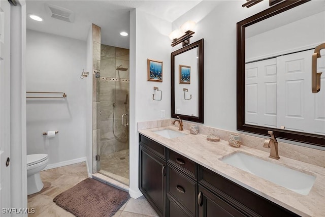 bathroom with tile patterned floors, toilet, vanity, and walk in shower