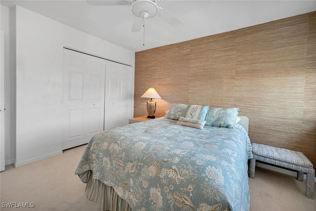 bedroom featuring ceiling fan, light carpet, and a closet