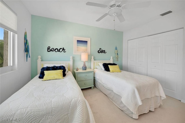 carpeted bedroom featuring ceiling fan and a closet