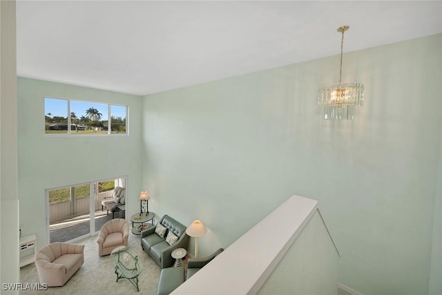 living room with an inviting chandelier, plenty of natural light, and a high ceiling