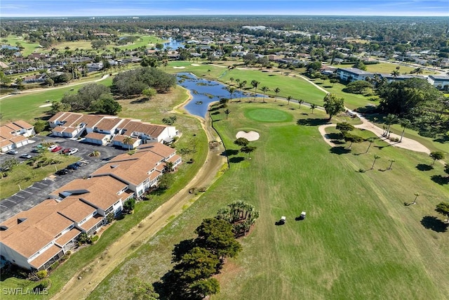 drone / aerial view featuring view of golf course, a water view, and a residential view