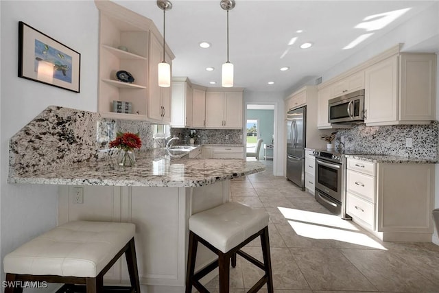 kitchen featuring stainless steel appliances, a peninsula, a sink, open shelves, and tasteful backsplash