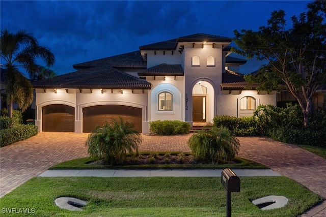 mediterranean / spanish home with a yard and a garage