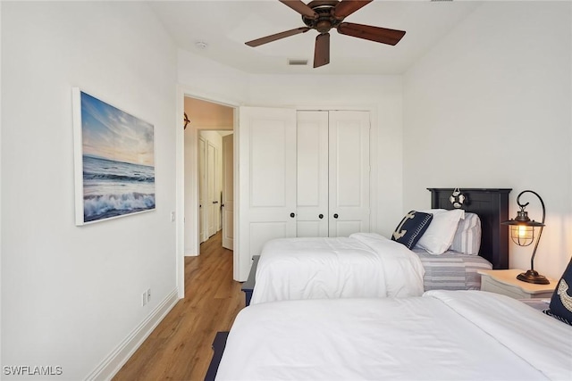 bedroom featuring hardwood / wood-style floors, ceiling fan, and a closet