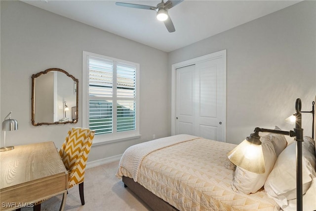 bedroom featuring a closet, ceiling fan, and light colored carpet