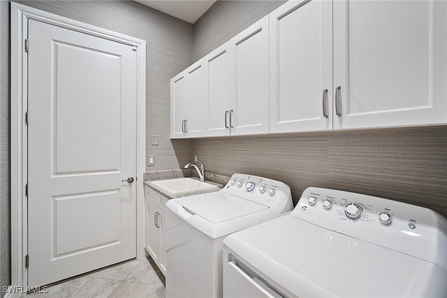 laundry area featuring cabinets, independent washer and dryer, light tile patterned floors, and sink