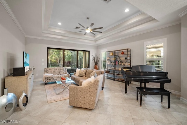 living room featuring light tile patterned floors, a tray ceiling, ceiling fan, and crown molding