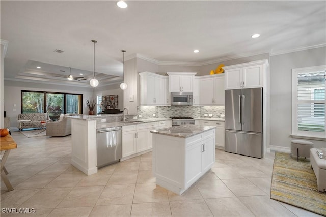 kitchen with sink, light stone countertops, appliances with stainless steel finishes, decorative light fixtures, and kitchen peninsula