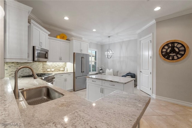 kitchen featuring sink, appliances with stainless steel finishes, tasteful backsplash, a kitchen island, and white cabinetry