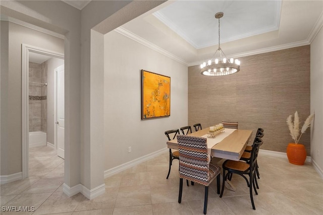 tiled dining space with ornamental molding, a raised ceiling, and a notable chandelier