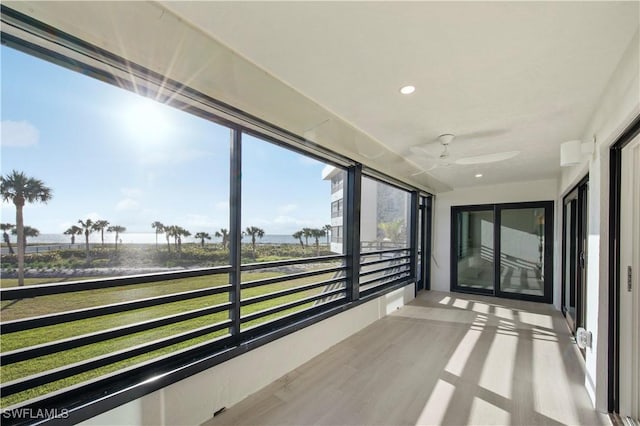 unfurnished sunroom featuring ceiling fan