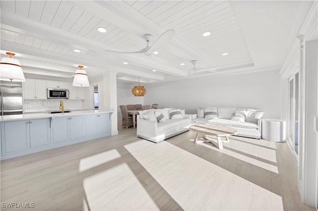 living room featuring ceiling fan, sink, wooden ceiling, beamed ceiling, and light hardwood / wood-style floors