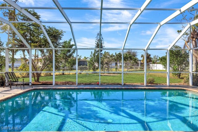 view of pool featuring a lawn and glass enclosure