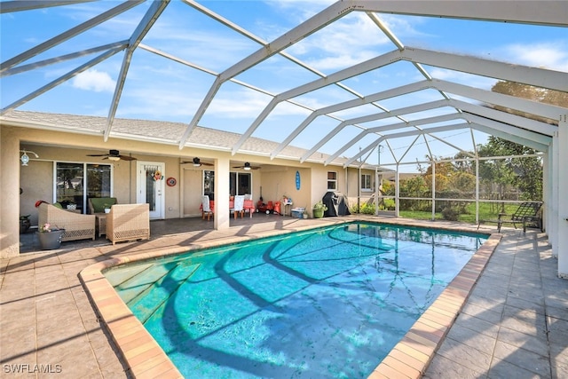 view of pool featuring an outdoor hangout area, a patio area, ceiling fan, and glass enclosure