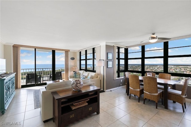 living room featuring a water view, a healthy amount of sunlight, and a wall of windows