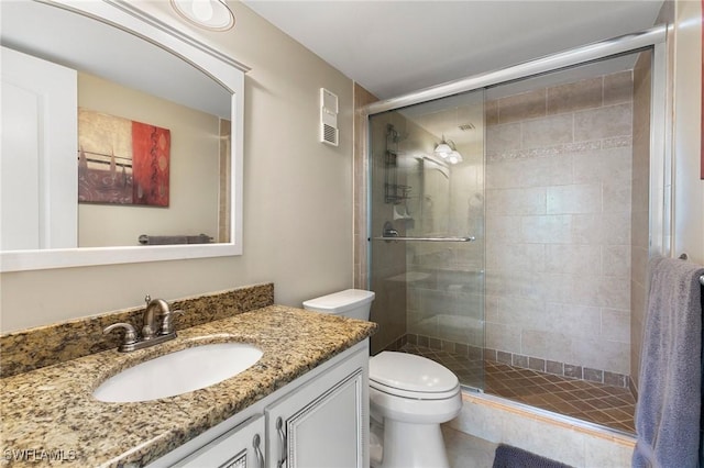 bathroom featuring vanity, toilet, and an enclosed shower