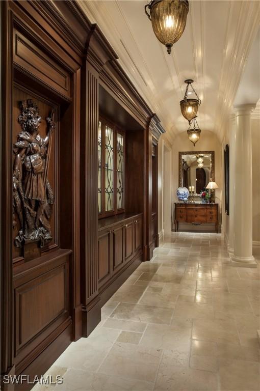 hall featuring ornate columns and ornamental molding