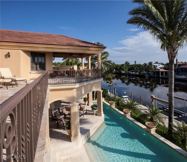 view of swimming pool with a patio and a water view