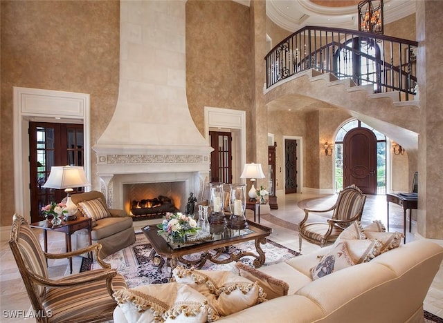 living room featuring crown molding, a fireplace, and a towering ceiling